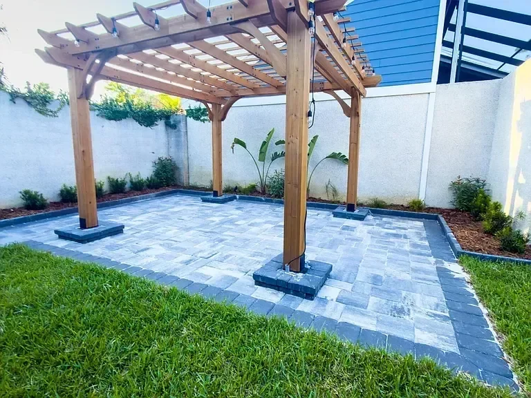 Paver patio with landscape lighting in residential yard