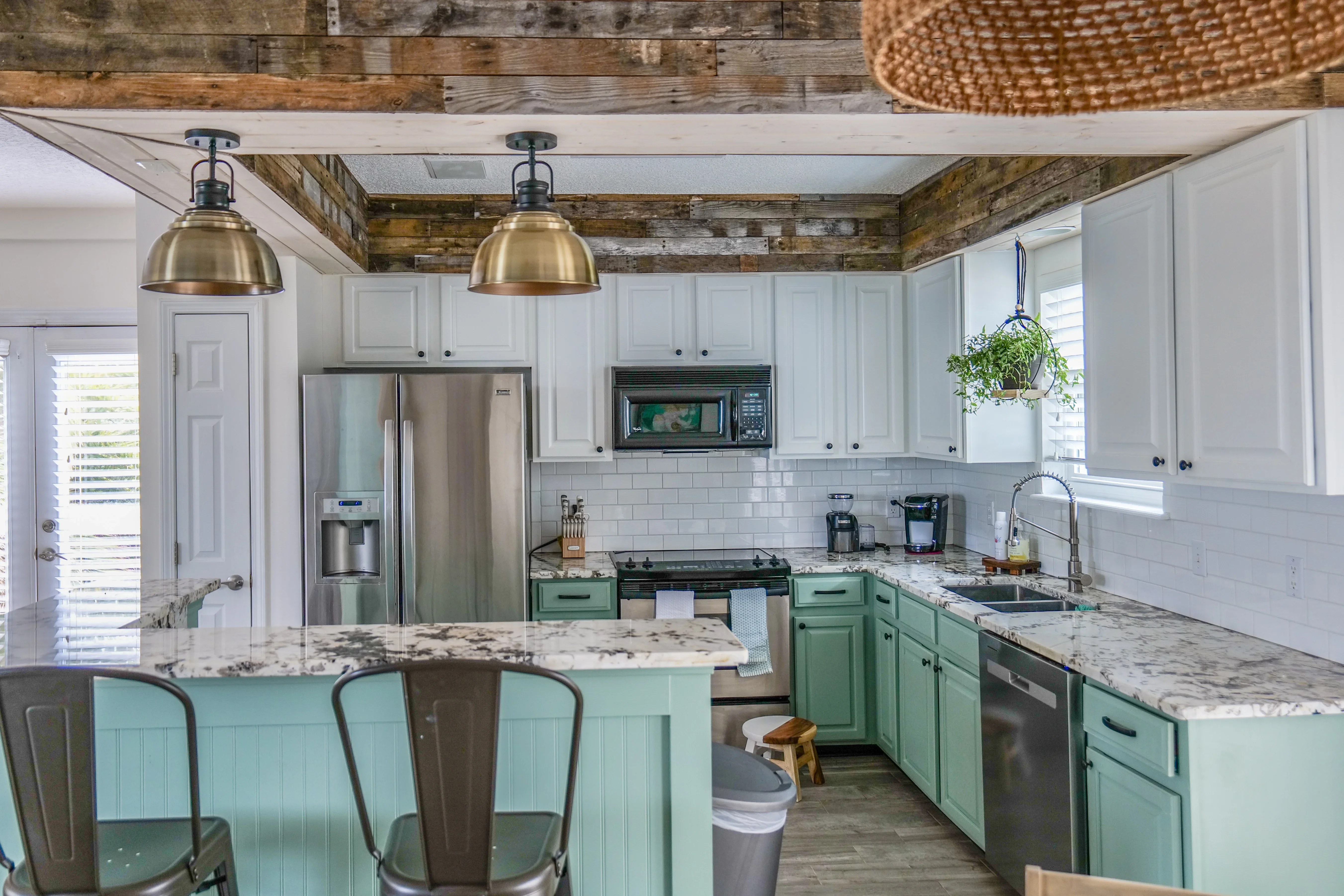 Kitchen with white and green cabinetry, granite counters, subway tile backsplash, and reclaimed wood ceiling beams